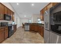 Spacious kitchen featuring brown cabinets, stainless steel appliances and an eat-in breakfast nook at 6523 Evergreen Park Dr, Lakeland, FL 33813