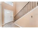 Bright entryway featuring neutral walls, tile flooring, a staircase with iron railing, and a front door with glass detailing at 2721 Stonewood Dr, Lakeland, FL 33810