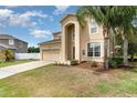 Charming two-story home with a two-car garage, arched entryway, and lush green lawn and mature landscaping at 2721 Stonewood Dr, Lakeland, FL 33810