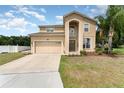 Charming two-story home with a two-car garage, arched entryway, and lush green lawn and mature landscaping at 2721 Stonewood Dr, Lakeland, FL 33810