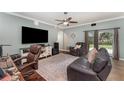 Cozy living room with a ceiling fan, leather furniture, a patterned rug, and a large television for entertainment at 2721 Stonewood Dr, Lakeland, FL 33810