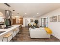Bright, open-concept living room featuring wood floors and an open flow to kitchen and dining areas at 1820 N Merrick Dr, Deltona, FL 32738