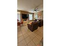 Inviting living room with large windows, tiled floors, comfortable seating and modern decor at 153 Tigerlily Ct, Davenport, FL 33837