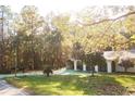 Charming single-story home featuring a manicured lawn, mature trees, and a convenient carport at 20732 Sw Marine Blvd, Dunnellon, FL 34431