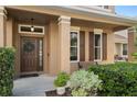 Inviting front entrance with a double door, complemented by a wreath and decorative landscaping at 460 Tess Ct, Orlando, FL 32834
