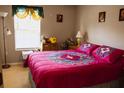 Cozy bedroom featuring a bright window with patterned curtains and colorful comforter on the bed at 4720 Vero Beach Pl, Kissimmee, FL 34746