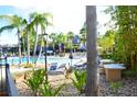 Community pool area with lounge chairs, landscaping and a decorative fence, surrounded by lush palm trees at 4720 Vero Beach Pl, Kissimmee, FL 34746