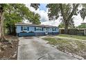 Charming single story home with blue painted wood siding and a long driveway in a lush and wooded lot at 5932 Hilltop E Ln, Lakeland, FL 33809