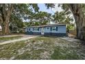 Charming single story home with blue painted wood siding and a walkway to the front door and manicured lawn at 5932 Hilltop E Ln, Lakeland, FL 33809
