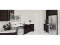 Modern kitchen featuring stainless steel appliances, dark cabinetry, and bright countertops at 7656 Gemstone St, Groveland, FL 34736
