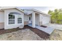 Newly renovated home showcasing fresh landscaping, a modern walkway, and a two-car garage at 2769 Corrigan Dr, Deltona, FL 32738