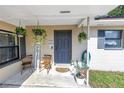 The cozy front porch is decorated with hanging plants, chairs, and a cute welcome sign at 4821 S Gachet Blvd, Lakeland, FL 33813