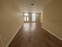 Bright living room showcasing wood flooring, fresh paint, and arched entryways at 2163 Wintermere Pointe Dr, Winter Garden, FL 34787
