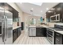 Modern kitchen featuring dark cabinetry, stainless steel appliances, light countertops, and updated flooring at 25302 Lido Ave, Sorrento, FL 32776