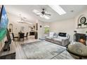 Bright, open living room with vaulted ceilings, skylights, fireplace and wood look floors that flow into the dining area at 25302 Lido Ave, Sorrento, FL 32776