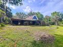 Home featuring a covered backyard space perfect for relaxing or entertaining with lush green surroundings at 2900 Cr 415, Lake Panasoffkee, FL 33538