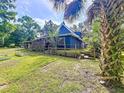 Cozy home featuring a fenced backyard with wooden steps leading to a charming outdoor space at 2900 Cr 415, Lake Panasoffkee, FL 33538