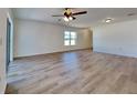 Spacious living room featuring laminate flooring, large windows, and a modern ceiling fan at 4601 Glencrest Loop, St Cloud, FL 34772