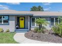 Close-up of a home showcasing a vibrant yellow front door and manicured landscaping at 1416 Leighton Ave, Lakeland, FL 33803