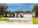 Charming one-story home boasts a bright white exterior, two-car garage, and well-maintained landscaping at 2418 Se 23Rd St, Ocala, FL 34471