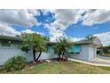 Quaint single-story home with a brick facade, complemented by well-maintained landscaping and mature palm trees at 1618 Pineberry St, Lakeland, FL 33803