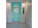 Inviting front entrance with a bright turquoise door, painted brick walls, and decorative welcome sign at 1618 Pineberry St, Lakeland, FL 33803