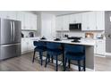 Bright kitchen featuring white cabinets, an island with seating, and stainless steel appliances at 6236 Sw 95Th Pl, Ocala, FL 34476