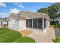 A bright exterior view shows the house's enclosed lanai and attached garage at 2121 Escobar Ave, Lady Lake, FL 32159
