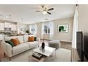 Bright and airy living room featuring a comfortable couch, modern decor, and a seamless flow to the kitchen at 392 Summer Squall Rd, Davenport, FL 33837