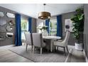 Elegant dining room featuring a round table, stylish chairs, modern lighting fixture, and decor at 6230 Sw 95Th Pl, Ocala, FL 34476