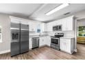 Modern kitchen with stainless steel appliances, white cabinets, and granite countertops at 1002 Ne 1St St, Mulberry, FL 33860