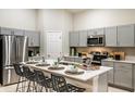 Modern kitchen featuring stainless steel appliances, gray cabinets, a quartz island and barstool seating at 1038 Foreshore Ln, Haines City, FL 33844