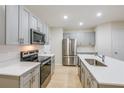 Spacious kitchen featuring stainless steel appliances, gray cabinets, and a center island at 3775 King Hill Dr, Haines City, FL 33844