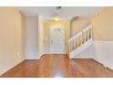 Inviting foyer with a staircase, featuring sleek hardwood floors and a well-lit entrance with a decorative door at 728 Waterbridge Dr, Winter Haven, FL 33880