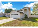 Charming two-story home featuring an attached two-car garage and well-manicured lawn under a bright blue sky at 728 Waterbridge Dr, Winter Haven, FL 33880