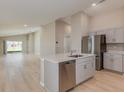 Open-concept kitchen with stainless steel appliances, island, and hardwood floors at 4015 Gardenia Ave, Lake Hamilton, FL 33851