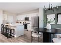 Open-concept kitchen with stainless steel appliances, island seating, and a dining area with a modern chandelier at 4027 Gardenia Ave, Lake Hamilton, FL 33851