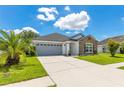 Attractive one-story house featuring a spacious driveway, two-car garage, and lush green lawn at 421 Sierra Mike Blvd, Lake Alfred, FL 33850