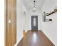 Inviting home foyer with modern light fixture, wood accent wall, and decorative wall decor at 421 Sierra Mike Blvd, Lake Alfred, FL 33850