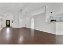 Bright open-concept living space with archways, hardwood flooring, and a modern light fixture at 421 Sierra Mike Blvd, Lake Alfred, FL 33850