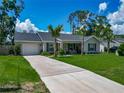 Charming single-story home featuring a well-manicured lawn, gray exterior and a cozy front porch at 4730 Se 141St Pl, Summerfield, FL 34491