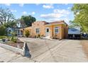 A wide driveway leads to this quaint stucco home with mature landscaping and a recreational vehicle at 1852 E Fern Rd, Lakeland, FL 33801