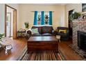 Cozy living room with hardwood floors, a brick fireplace, and comfortable seating at 1852 E Fern Rd, Lakeland, FL 33801