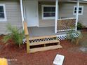 Inviting front porch with a wooden step, lattice accents, and updated porch at 2212 Ne 11 Ct, Ocala, FL 34470