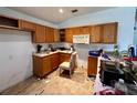 Outdated kitchen featuring wood cabinets, laminate countertops, and an empty refrigerator space at 11928 Se 91St Cir, Summerfield, FL 34491