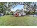 Spacious front yard featuring a charming home with a wooden deck and black chain link fence at 208 Se 32Nd Ave, Ocala, FL 34471