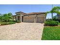 Charming single-story home with a brick driveway, tile roof, manicured landscaping, and a two-car garage at 1839 Via Lago Dr, Lakeland, FL 33810
