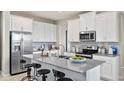 Modern kitchen featuring stainless steel appliances, white cabinets, and a large island at 2437 Spring Tune Aly, Kissimmee, FL 34744