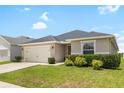 This single-story home features a well-manicured lawn and a two-car garage at 3839 White Ibis Rd, Lakeland, FL 33811
