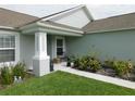 The home has a lovely covered front porch with decorative plants and bench seating at 206 Samantha Ave, Auburndale, FL 33823